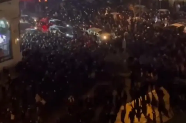 Yıkılmış bir bina önünde protestocular