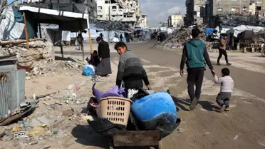 Gazze'de yıkılmış bir bina önünde insanlar