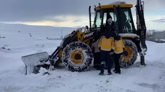 Karlı yol üzerinde iş makinesi ve ambulans